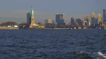 Statue von Freiheit und städtisch Stadtbild im das Morgen, Neu York Stadt, vereinigt Zustände von Amerika. Aussicht von das Wasser. Steadicam Schuss video