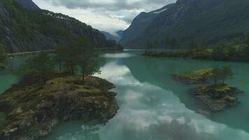 lovatnet Lac avec turquoise l'eau. vert îles et montagnes dans été journée. Norvège. aérien voir. drone est en volant vers l'avant et ascendant video