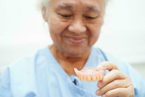 Doctor holding teeth denture in hand for dentist studying about dentistry. photo