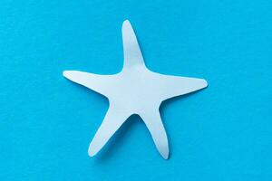 estrella de mar papel cortar aislado en azul foto