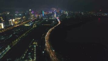 Shenzhen stad Bij nacht. futiaan wijk stedelijk horizon en Shenzhen baai. guangdong, China. antenne visie. dar vliegt naar voren, kantelen omhoog, onthullen schot video