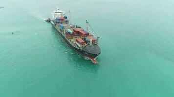 Container Ship in the Sea. Aerial View. Drone is Flying Backwards, Camera Tilts Up video