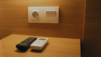 Television remote and air conditioner remote on the table photo