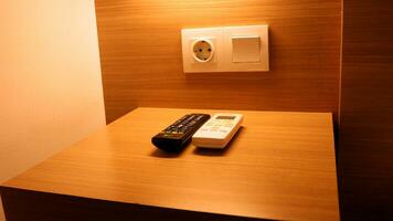 Television remote and air conditioner remote on the table photo