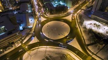 illuminé circulation cercle dans le ville et voitures à hiver nuit. rond carrefour. aérien verticale de haut en bas voir. drone hyper laps. en orbite video