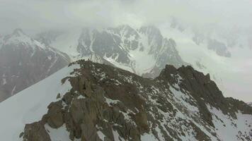 montanhistas em topo do montanha. tian shan, quirguistão. aéreo visualizar. zangão é órbita sentido anti-horário video