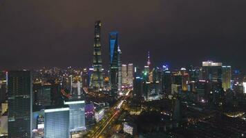 shanghai stadsbild på natt. lujiazui distrikt och upplyst horisont. Kina. antenn se. Drönare flugor sidled och uppåt video