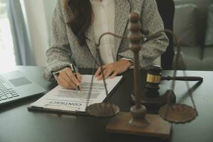 Business and lawyers discussing contract papers with brass scale on desk in office. Law, legal services, advice, justice and law concept picture with film grain effect photo