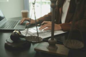 Business and lawyers discussing contract papers with brass scale on desk in office. Law, legal services, advice, justice and law concept picture with film grain effect photo