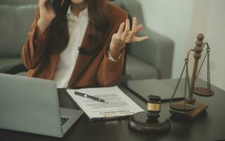 Business and lawyers discussing contract papers with brass scale on desk in office. Law, legal services, advice, justice and law concept picture with film grain effect photo