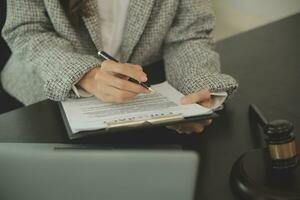 Business and lawyers discussing contract papers with brass scale on desk in office. Law, legal services, advice, justice and law concept picture with film grain effect photo