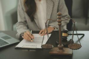 Business and lawyers discussing contract papers with brass scale on desk in office. Law, legal services, advice, justice and law concept picture with film grain effect photo