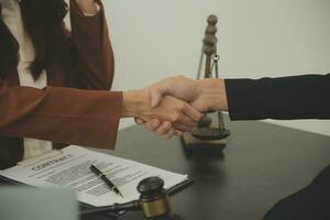 Business and lawyers discussing contract papers with brass scale on desk in office. Law, legal services, advice, justice and law concept picture with film grain effect photo