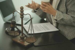 Business and lawyers discussing contract papers with brass scale on desk in office. Law, legal services, advice, justice and law concept picture with film grain effect photo