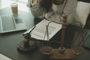 Business and lawyers discussing contract papers with brass scale on desk in office. Law, legal services, advice, justice and law concept picture with film grain effect photo