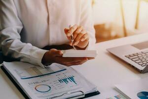 businessman working on desk office with using a calculator to calculate the numbers, finance accounting concept photo