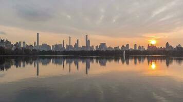 Manhattan Skyline and Reflection in Lake in Central Park at Sunset. New York City. United States of America. Day to Night Time Lapse video