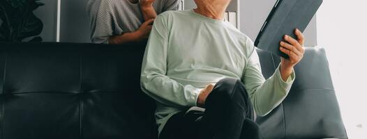 Embraced mature couple surfing the Internet on laptop at home photo