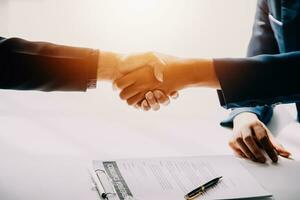 A car rental company employee is handing out the car keys to the renter after discussing the rental details and conditions together with the renter signing a car rental agreement. Concept car rental. photo