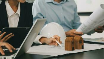 Construction and structure concept of Engineer or architect meeting for project working with partner and engineering tools on model building and blueprint in working site, contract for both companies. photo