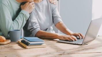 Happy mature couple using laptop at home photo