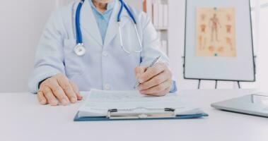 Mature Asian male doctor talking with his patient, explaining the procedure to old lady. photo