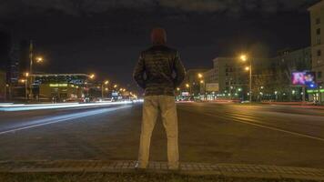 hora lapso de hombre en pie todavía y tráfico de carros en autopista a noche. iluminado ciudad video