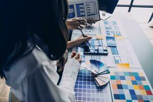 Close up ux developer and ui designer brainstorming about mobile app interface wireframe design on table with customer breif and color code at modern office.Creative digital development agency photo