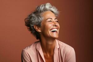 Senior woman laughing heartily isolated on a burnt sienna gradient background photo