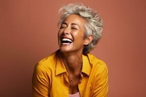 Senior woman laughing heartily isolated on a burnt sienna gradient background photo