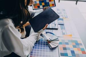 Close up ux developer and ui designer brainstorming about mobile app interface wireframe design on table with customer breif and color code at modern office.Creative digital development agency photo