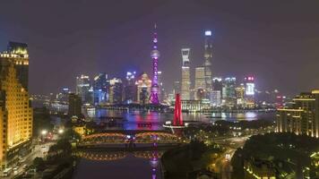 Xangai Horizonte às noite. urbano Lujiazui distrito, Huangpu rio e waibaidu ponte. China. aéreo hiper lapso, Tempo lapso. zangão é vôo para trás e para cima video