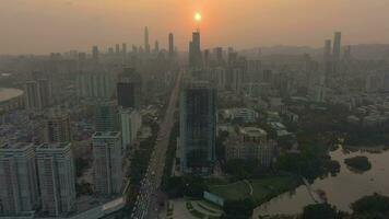 shenzhen ciudad a puesta de sol. porcelana. aéreo vista. zumbido moscas adelante, inclinación arriba. revelar Disparo video