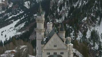 Neuschwanstein Castle on Rock in Winter Day. Mountains and Rocks. Bavarian Alps, Germany. Aerial View. Medium Shot. Drone is Orbiting Counterclockwise, Flies Downwards video