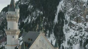 neuschwanstein slott i vinter- dag och staty. bergen och snö fält. bavarian alperna, Tyskland. antenn se. medium skott. Drönare är kretsande moturs, flugor uppåt video