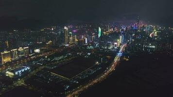 Shenzhen Stadt beim Nacht. Futian Kreis und Shenzhen Bucht. Guangdong, China. Antenne Sicht. Drohne fliegt seitwärts video