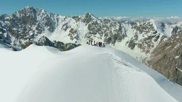 People on Top of Snow-Capped Mountain in Sunny Day. Aerial View. Drone is Orbiting Counterclockwise video