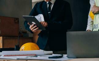 Diverse Team of Specialists Use Tablet Computer on Construction Site. Real Estate Building Project with Civil Engineer, Architect, Business Investor and General Worker Discussing Plan Details. photo