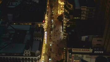 mensen Bij nanking weg Bij nacht. voetganger straat in huangpu wijk. Shanghai stad, China. antenne visie. dar vliegt achteruit. video