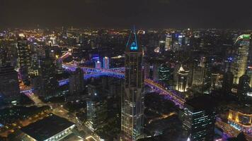 iluminado llevar a la fuerza ciudad a noche. huangpu paisaje urbano porcelana. aéreo vista. zumbido moscas oblicuo y hacia abajo video