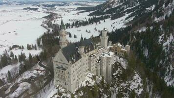 neuschwanstein slott i vinter- dag. bergen och skog. bavarian alperna, Tyskland. antenn se. bred skott. Drönare är kretsande moturs video