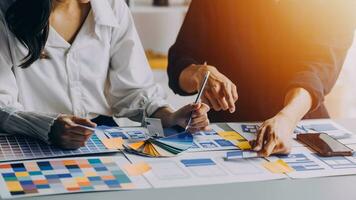Close up ux developer and ui designer brainstorming about mobile app interface wireframe design on table with customer breif and color code at modern office.Creative digital development agency photo