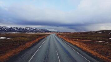 Large roads and snowy mountain tops with frozen green fields in iceland, aerial view of nordic roadside with spectacular scenery. Scandinavian nature and icelandic landscapes. photo