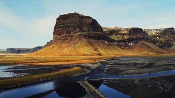 Drone shot of majestic mountain top in iceland, large mountain range with snowy hills near frozen countryside fields. Beautiful icelandic scenery with nordic nature and lands. Slow motion. photo