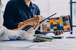 Close up ux developer and ui designer brainstorming about mobile app interface wireframe design on table with customer breif and color code at modern office.Creative digital development agency photo