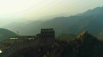 génial mur de Chine et vert montagnes dans été le coucher du soleil. aérien voir. drone est en orbite video