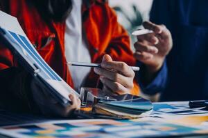 Close up ux developer and ui designer brainstorming about mobile app interface wireframe design on table with customer breif and color code at modern office.Creative digital development agency photo