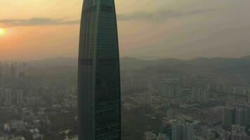 Shenzhen, China - maart 28, 2019 kk100 wolkenkrabber en stadsgezicht Bij zonsondergang. antenne visie. dar is in een baan om de aarde video