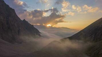 montañas y nubes a puesta de sol. aéreo hiper lapso, hora lapso. zumbido moscas adelante video