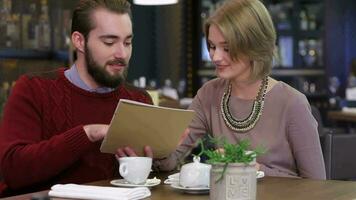 souriant couple en train de lire menu et choisir repas video